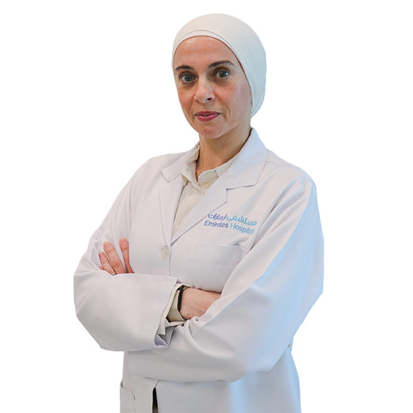 Female doctor in a white coat and headscarf with arms crossed, posing for a staff photo at Emirates Hospital.
