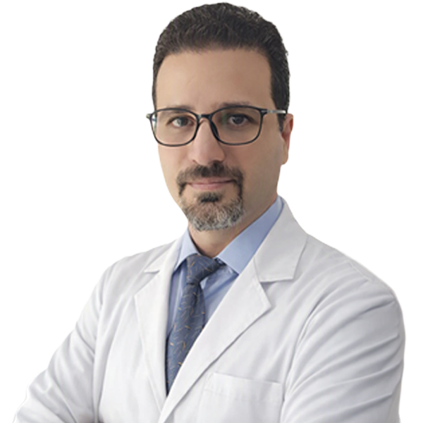Male doctor wearing glasses and a white lab coat, blue shirt and striped tie, looking at the camera.